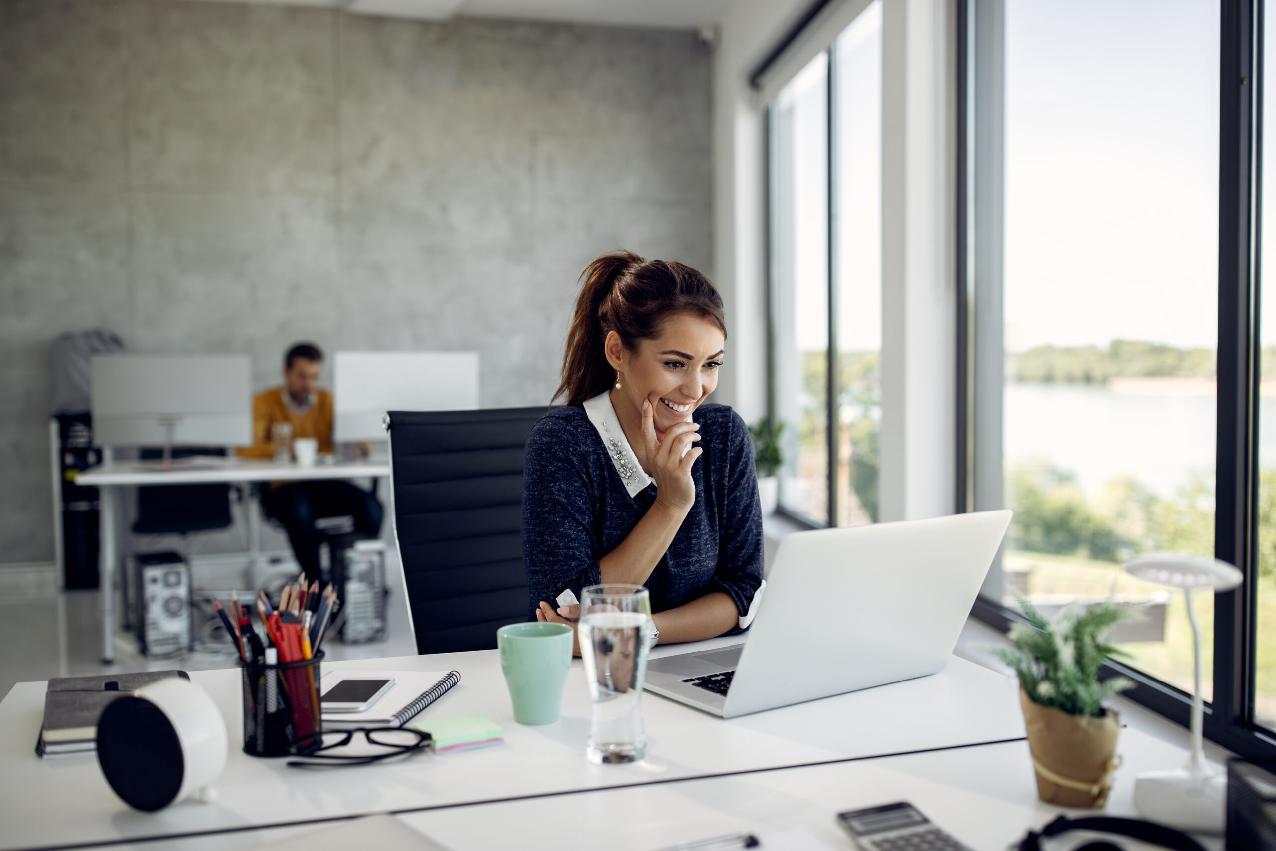 Young happy businesswoman working on a computer and reading an e-mail in the office.